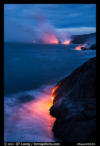 Molten lava pouring over sea cliffs at dawn. Hawaii Volcanoes National Park, Hawaii, USA.