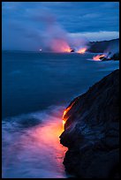 Molten lava pouring over sea cliffs at dawn. Hawaii Volcanoes National Park, Hawaii, USA. (color)
