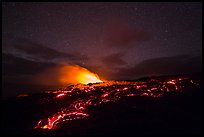 Molten lava flow and plume from ocean entry with stary sky at night. Hawaii Volcanoes National Park, Hawaii, USA.