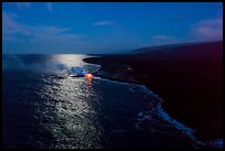 Aerial view of coastline with distant lava ocean entry and moonlight reflections at night. Hawaii Volcanoes National Park ( color)