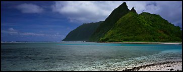 Tropical landscape with blue waters, pointed peaks, and clouds, Ofu Island. National Park of American Samoa (Panoramic color)