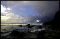 Boulders and coastline at sunrise with rainbow, Siu Point, Tau Island. National Park of American Samoa
