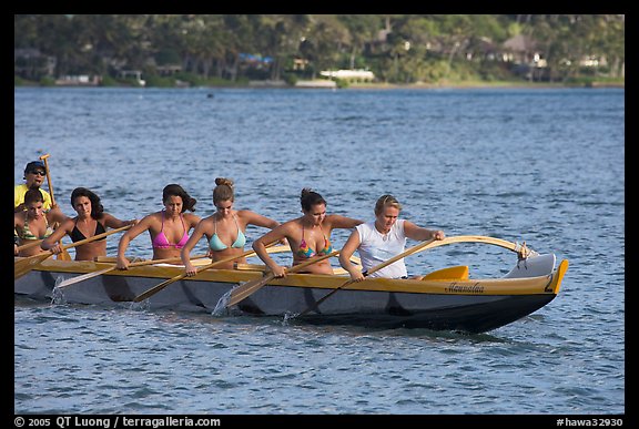 Outrigger canoe paddled by women in bikini, Maunalua Bay, late afternoon. Oahu island, Hawaii, USA