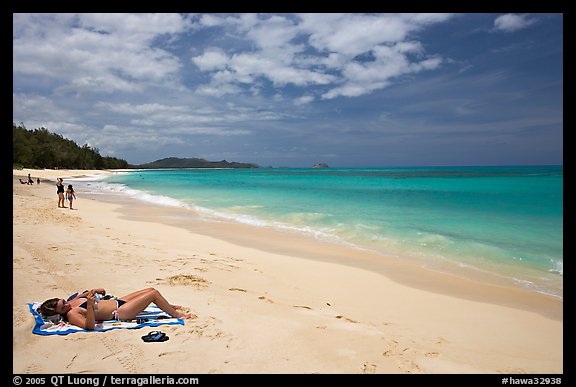 Woman sunning herself on Waimanalo Beach. Oahu island, Hawaii, USA