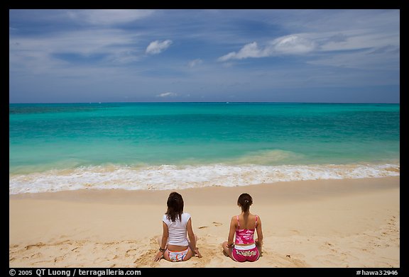 Young women facing the Ocean in a meditative pose on Waimanalo Beach. Oahu island, Hawaii, USA