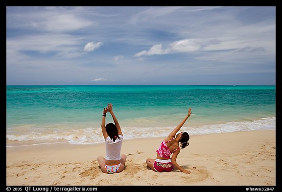 Young women stretching on Waimanalo Beach. Oahu island, Hawaii, USA