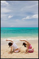 Young women doing gymnastics on Waimanalo Beach. Oahu island, Hawaii, USA ( color)
