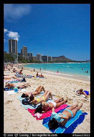 Young women on Waikiki Beach with skyline in the background. Waikiki, Honolulu, Oahu island, Hawaii, USA (color)