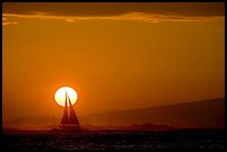Sailboat and sun disk, sunset. Waikiki, Honolulu, Oahu island, Hawaii, USA