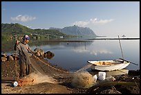 Fisherman pulling out net out of small baot, Kaneohe Bay, morning. Oahu island, Hawaii, USA (color)