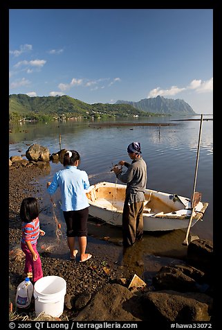 Fishing family working around small baot, Kaneohe Bay, morning. Oahu island, Hawaii, USA (color)