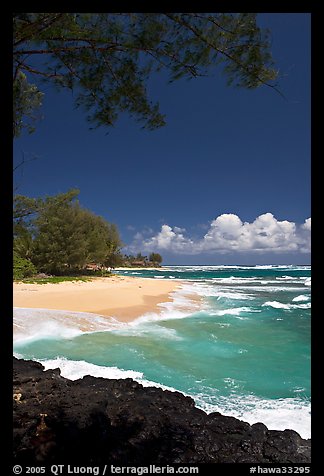 Beach, volcanic rock, and turquoise waters, and homes  near Haena. North shore, Kauai island, Hawaii, USA (color)