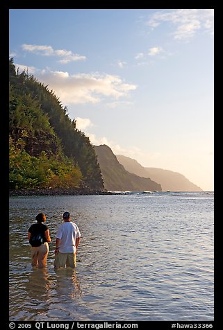 Couple looking at the Na Pali Coast, Kee Beach, late afternoon. Kauai island, Hawaii, USA (color)