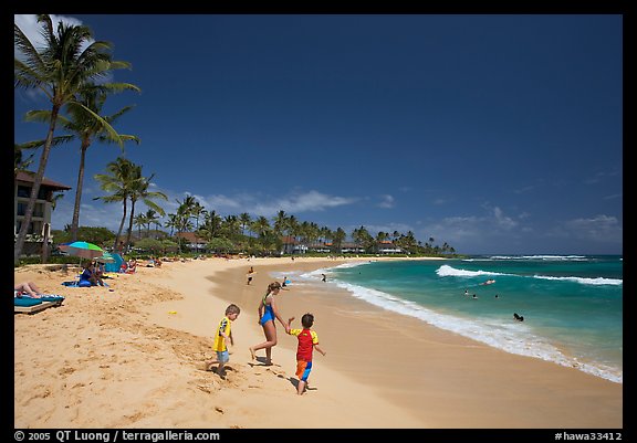 Children playing around, Kiahuna Beach, mid-day. Kauai island, Hawaii, USA