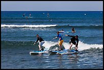 Surfing students ride the same wave. Lahaina, Maui, Hawaii, USA