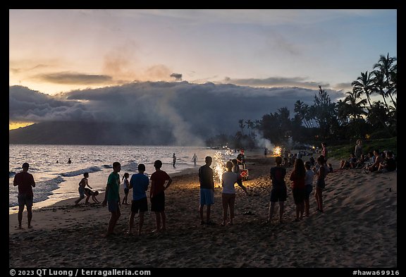 Revelers on Kamahole Beach with fireworks, Kihei. Maui, Hawaii, USA (color)