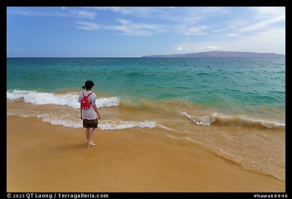 Girl stepping into water, Big Beach. Maui, Hawaii, USA