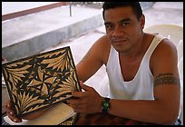 Young man showing an artwork based on traditional siapo designs. Pago Pago, Tutuila, American Samoa (color)