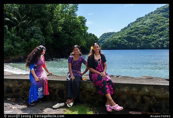 Samoan girls sitting on seawall, Fagasa. Tutuila, American Samoa (color)