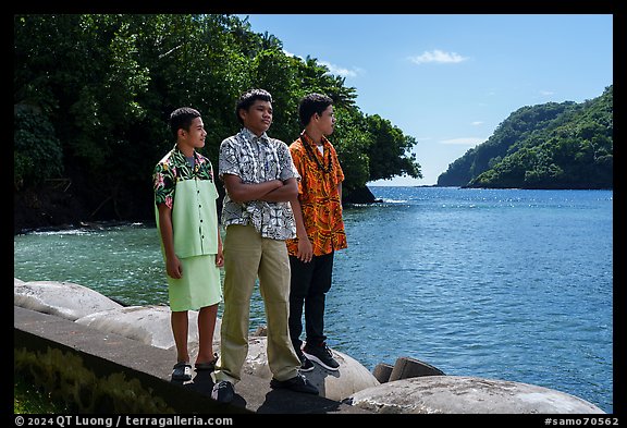 Samoan boys standing on seawall, Fagasa. Tutuila, American Samoa (color)