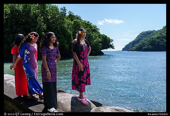Samoan girls standing on seawall in Fagasa Bay. Tutuila, American Samoa (color)