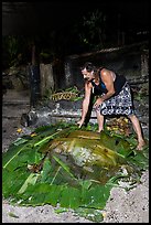 Candy Mann taking out banana leaves to uncover Umu earth oven, Tisa Barefoot Bar. Tutuila, American Samoa ( color)