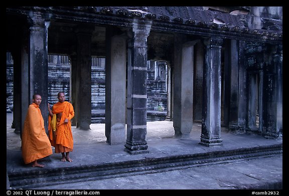 Two Buddhist monks in dark temple, Angkor Wat. Angkor, Cambodia