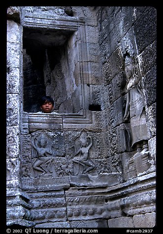 Boy hides in the Bayon. Angkor, Cambodia