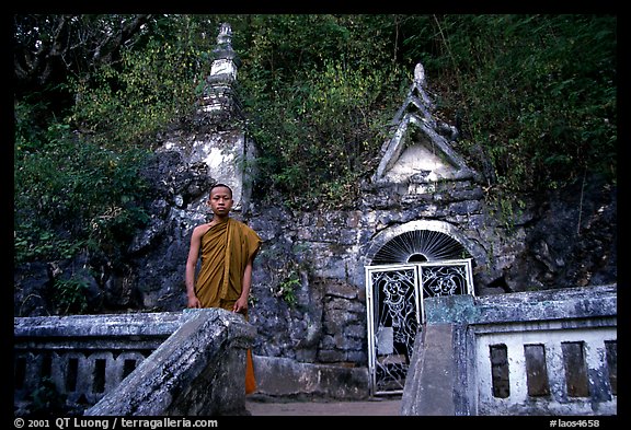 Novice Buddhist monk at entrance of cave, Pak Ou. Laos