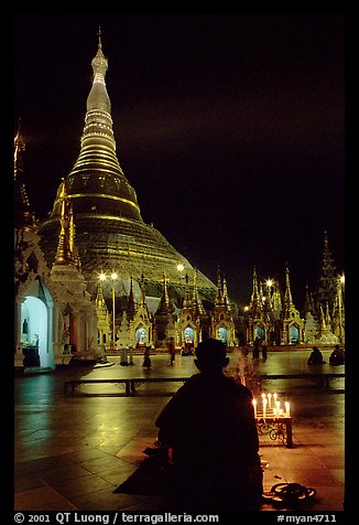 Praying at the wish-fullfilling place by night , Shwedagon Paya. Yangon, Myanmar