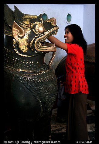 Rubbing an Angkor bronze statue at Mahamuni Paya. Mandalay, Myanmar (color)