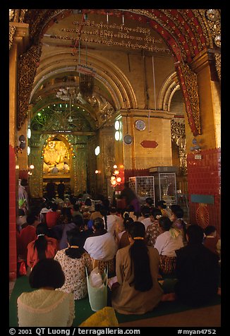 Woman praying at the venerated Mahamuni image. Mandalay, Myanmar (color)