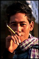 Man enjoying a cheerot (burmese cigar). Mandalay, Myanmar (color)