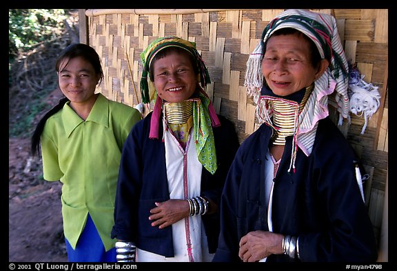 Three generations of Padaung women	along hut. Shan state, Myanmar