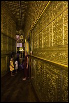 Worshippers inside maze-like walkway lined with glass showcases, Botataung Pagoda. Yangon, Myanmar ( color)