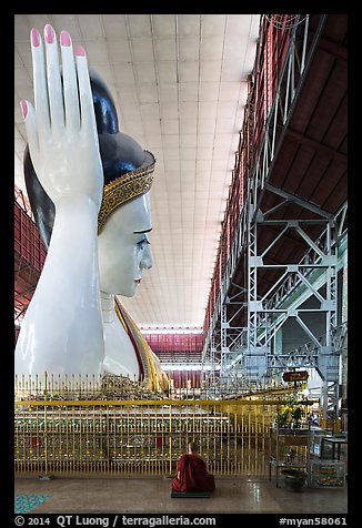 Monk and reclining Buddha statue housed in large metal shed, Kyauk Htat Gyi Pagoda. Yangon, Myanmar (color)
