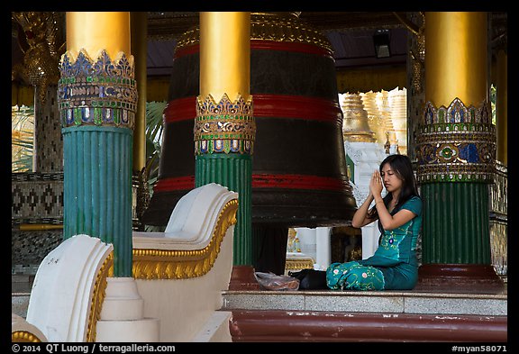 Woman praying next to bell, Shwedagon Pagoda. Yangon, Myanmar (color)
