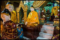 Woman and monk in pavillion surrounded by Buddha statues. Yangon, Myanmar ( color)