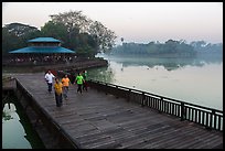 People walking for exercise at dawn, Kandawgyi Lake Park. Yangon, Myanmar ( color)