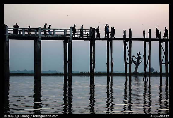 U Bein Bridge with monks and visitors strolling at dusk. Amarapura, Myanmar (color)