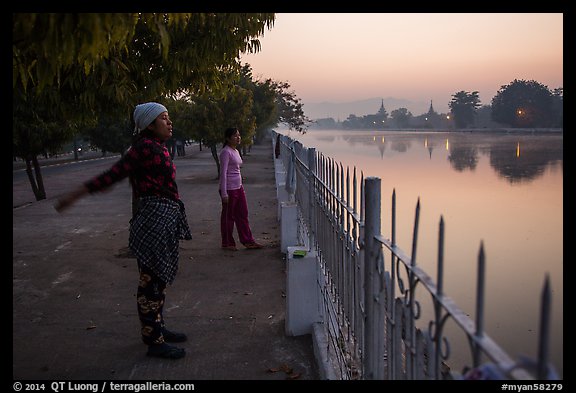 Women exercising next to Mandalay Fort at dawn. Mandalay, Myanmar (color)