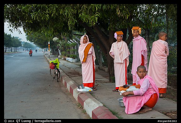 Nuns waiting for ride on sidewalk. Mandalay, Myanmar (color)