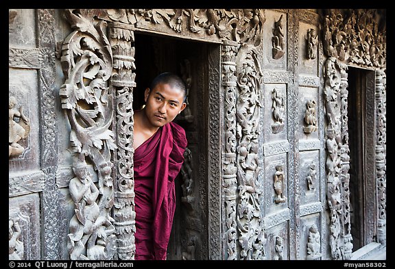 Exquisitely carved teak walls and monk pearing, Shwe In Bin Kyaung pagoda. Mandalay, Myanmar (color)