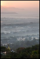 Fog shrouded plain below Mandalay Hill at sunrise. Mandalay, Myanmar ( color)