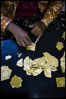 Close-up of hands separating gold leaves. Mandalay, Myanmar ( color)
