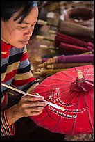 Woman painting the paper sun umbrellas carried by the monks. Pindaya, Myanmar ( color)