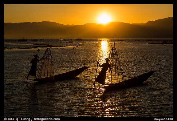 Intha fishermen row with leg with setting sun. Inle Lake, Myanmar