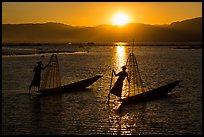 Intha fishermen row with leg with setting sun. Inle Lake, Myanmar ( color)