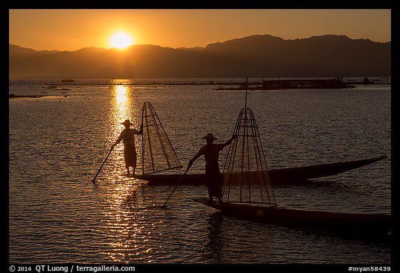 Intha fishermen on long flat-bottomed boats at sunset. Inle Lake, Myanmar (color)