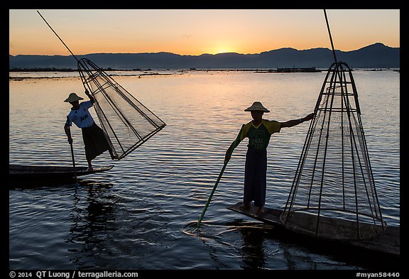 Intha fishermen lifting traditional conical net at sunset. Inle Lake, Myanmar